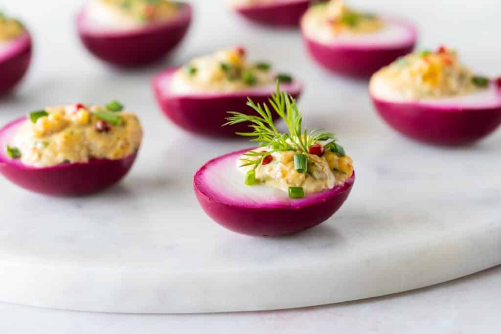 A marble slab topped with beet juice soaked devilled eggs for Easter | Aux Fourneaux