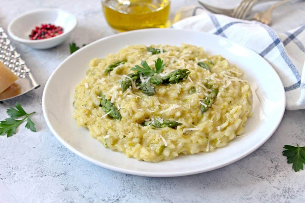 Italian risotto with spring asparagus and parmesan cheese on light background Top view with copy space | Aux Fourneaux Risotto crémeux aux asperges facile et rapide recette italienne au parmesan