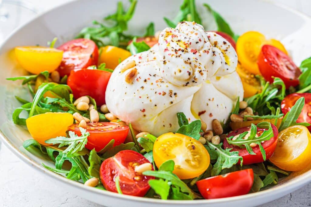 Close-up of burrata cheese salad with arugula and tomatoes | Aux Fourneaux Recette burrata tomate vinaigre balsamique