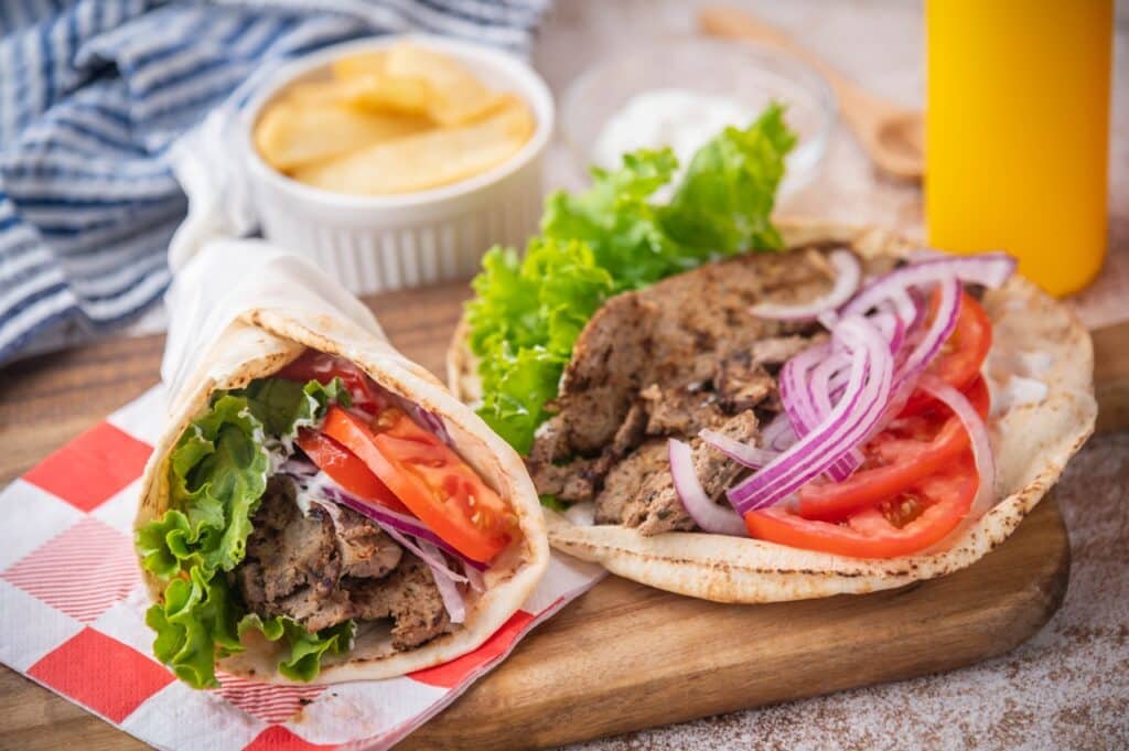 gyro wrap on wooden cutting board | Aux Fourneaux Sandwich grec ou Gyro recette maison traditionnelle