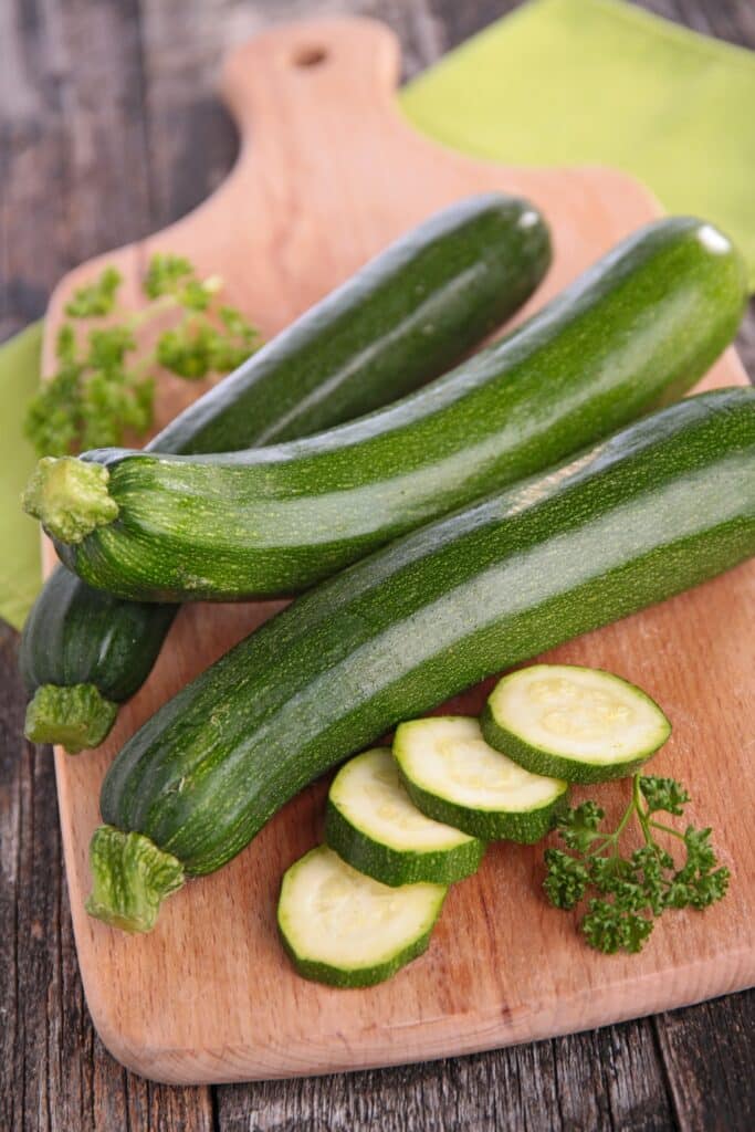raw zucchini on wooden board | Aux Fourneaux Faut-il enlever la peau des courgettes pour un gratin