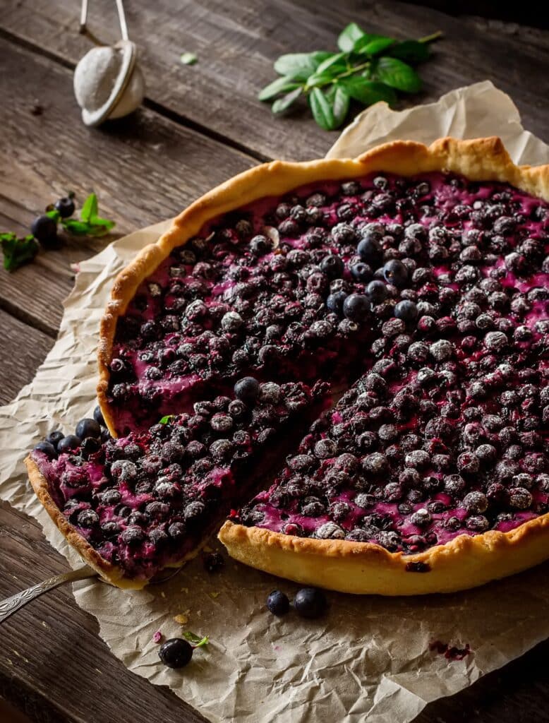 Homemade pie with bilberry on dark wooden table | Aux Fourneaux vraie recette de tarte aux myrtilles d’Alsace traditionnelle