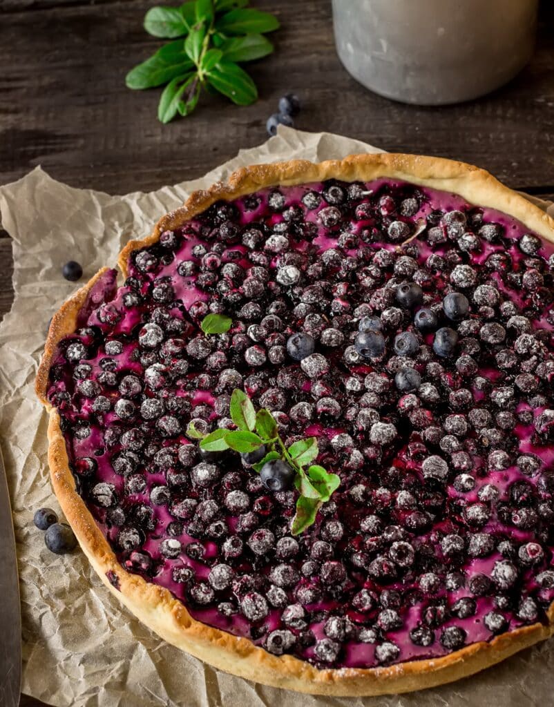 Homemade pie with bilberry on dark wooden table | Aux Fourneaux recette de la vraie tarte aux myrtilles d’Alsace traditionnelle